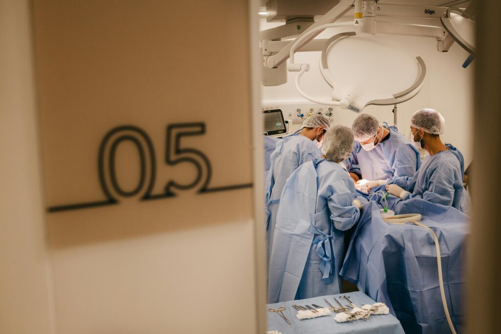 pexels-photo-13697927-13697927 A group of surgeons operates in a hospital's sterile environment, focusing on a complex procedure.