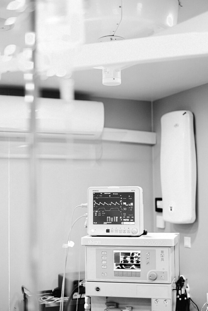 pexels-photo-4421501-4421501 Black and white photo of an ECG monitor in a hospital showing vital signs and medical equipment.